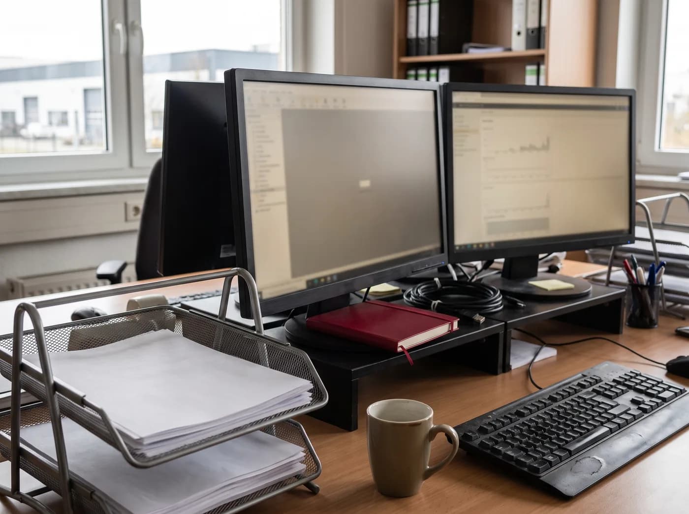 Arbeitsplatz im technischen Innendienst mit Monitoren, Ablagefach und Tastatur