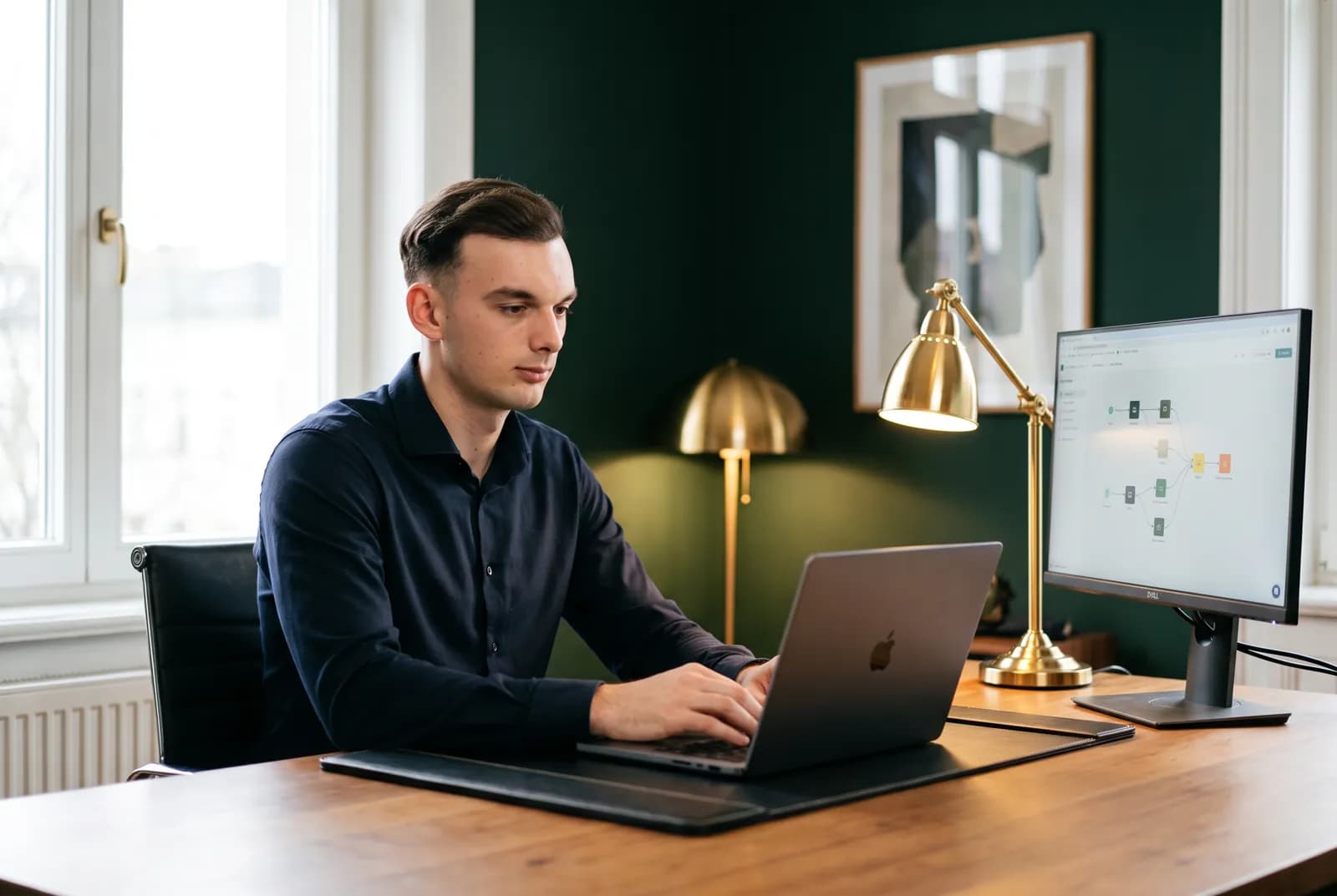 Besnik Zeka baut im Büro einen Automatisierungs-Workflow am großen Monitor